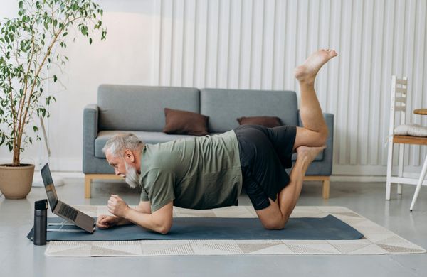 Man holding a static plank position on a yoga mat.